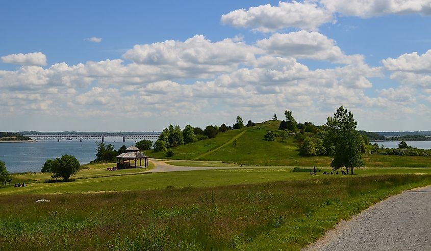 Lush Spectacle Island with fluffy clouds and green grass.