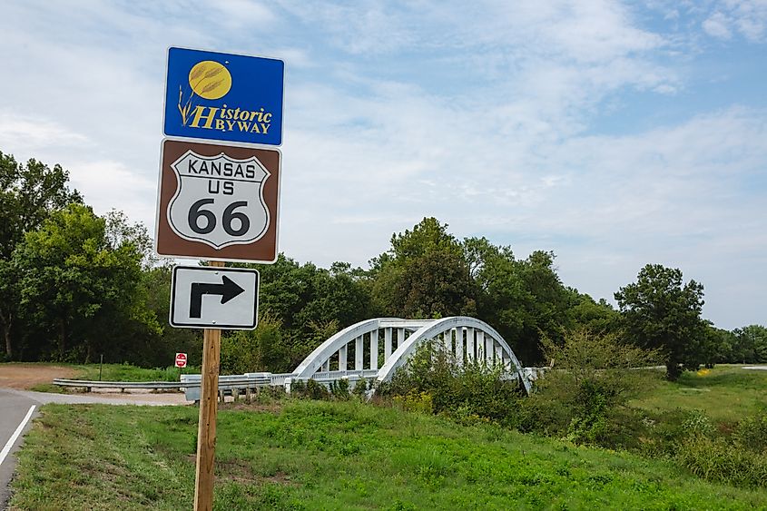 A Route 66 marker stands near the historic Rainbow Bridge in Baxter Springs, Kansas