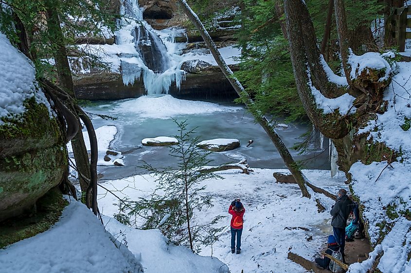 Logan Ohio United States. Hikers take in the winter view of Cedars Falls in Hocking Hills Ohio. Editorial credit: arthurgphotography / Shutterstock.com