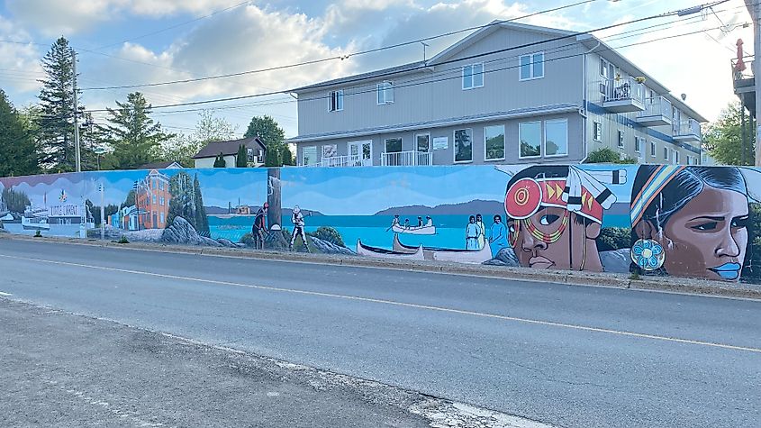 An outdoor mural showing the history of Manitoulin Island from its Indigenous roots to European settlers, to the Industrial Revolution and beyond 