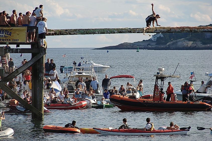 A man attempts to reach the flag during the courtesy round of the Greasy Pole.