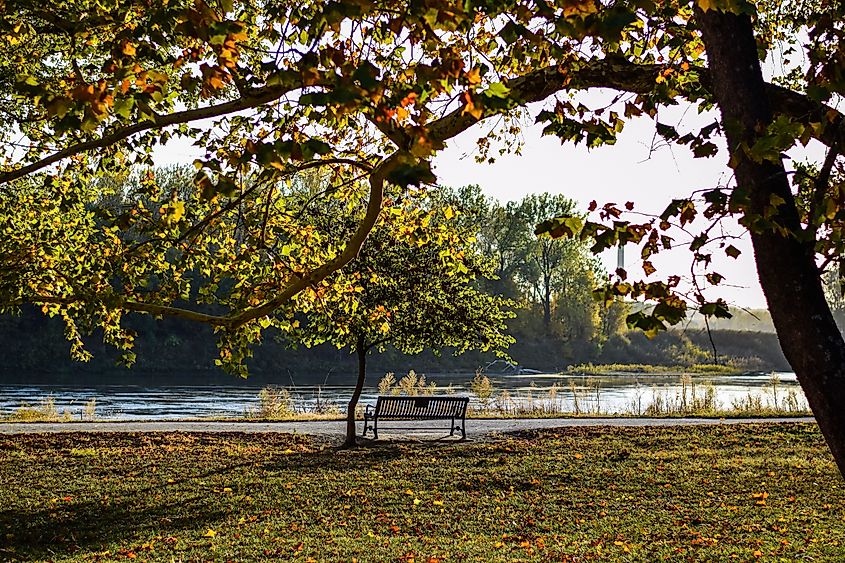 A bench next to the Missouri River in English Landing Park in Parkville, Missouri, on a fall day.