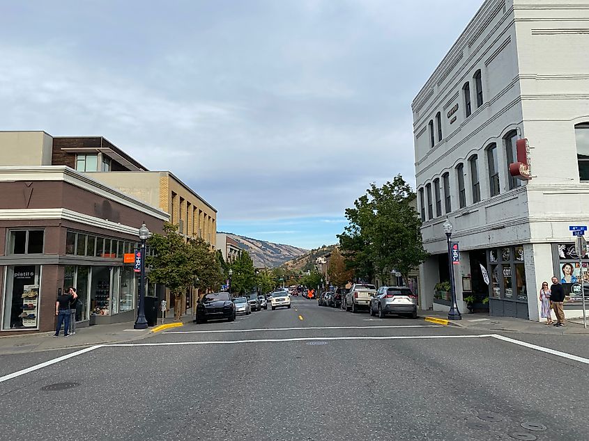 A quiet pedestrian intersection in downtown Hood River, with the mountains of the Columbia Gorge seen in the background.