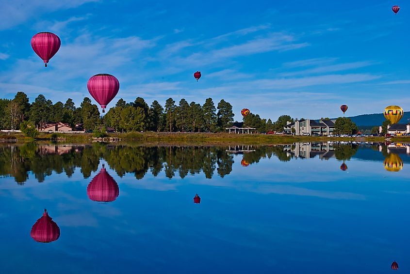 Hot air balloon festival in Pagosa Springs Colorado an amazing getaway on a mirror still lake reflecting colorful balloons all over the morning sky.