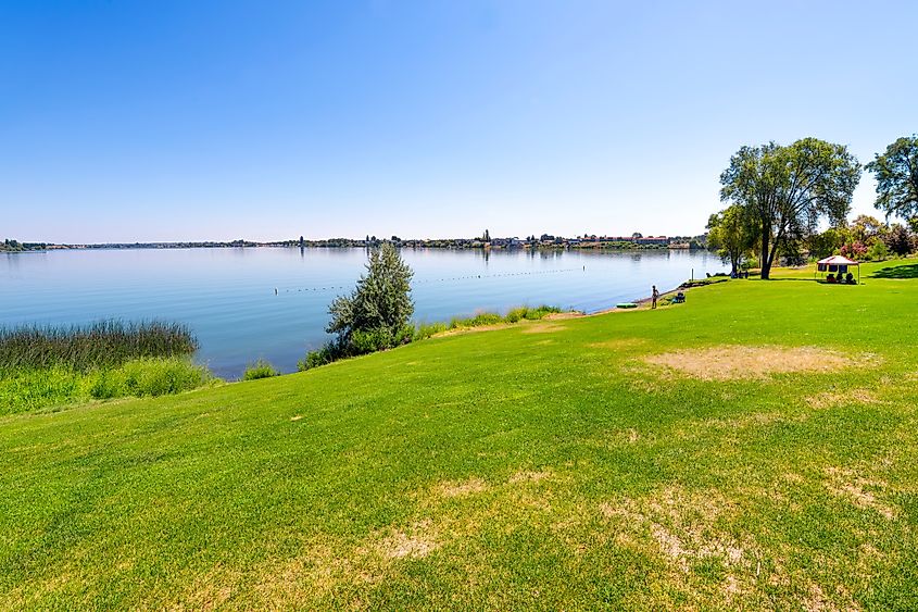 A summer day at the 24-acre Blue Heron Park in Moses Lake, Washington, featuring a peaceful lakeside setting with green spaces and recreational areas.