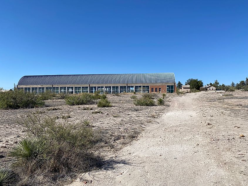 An old brick military hanger in the midst of a desert landscape. 