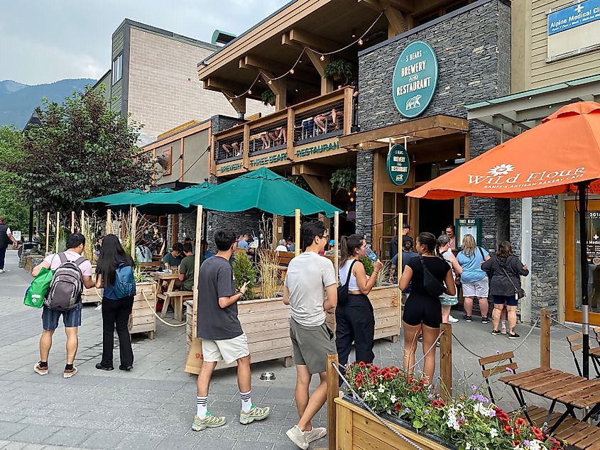 A small crowd gathers around the streetside patio of Three Bears Brewery in Banff.