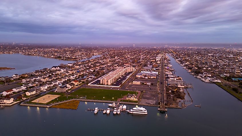 A high angle, aerial view of Freeport, NY from over the marsh waters in Baldwin Bay, during a cloudy sunrise.