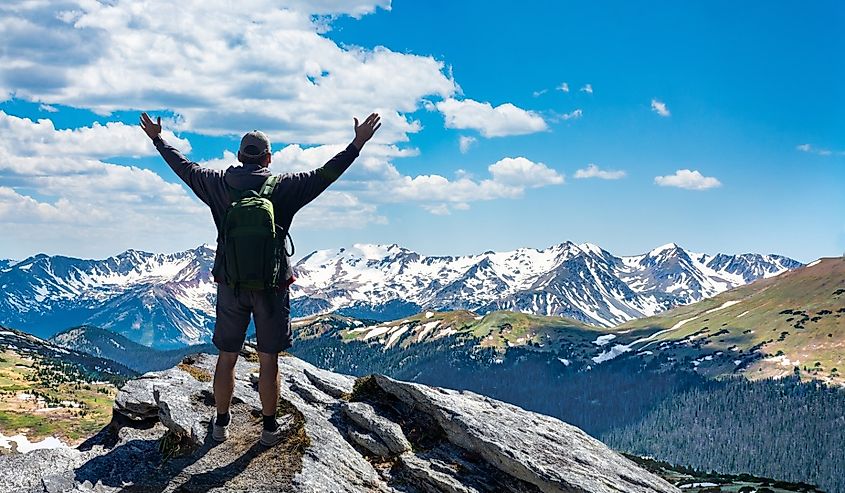 Hiker with arms up standing on the top of the mountain inRocky Mountains National Park, Colorado