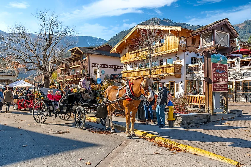 A horse-drawn carriage carrying tourists through the colorful Bavarian-themed village of Leavenworth, Washington.