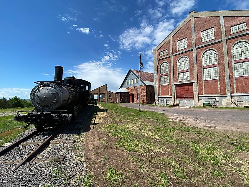 An old train sits outside of the preserved Quincy Mine brick factories