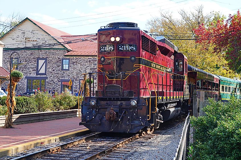 Vintage New Hope and Ivyland Railroad train on tracks in New Hope, PA, ready for scenic tours through Bucks County, reflecting the region's rich railway history.