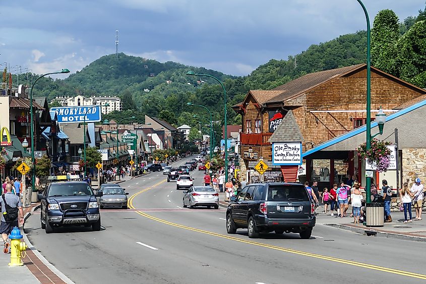 Busy summer street in Gatlinburg, Tennessee, with tourists and cars.