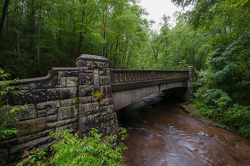 Stone bridge in Brevard, NC, in Forest with river running under it.