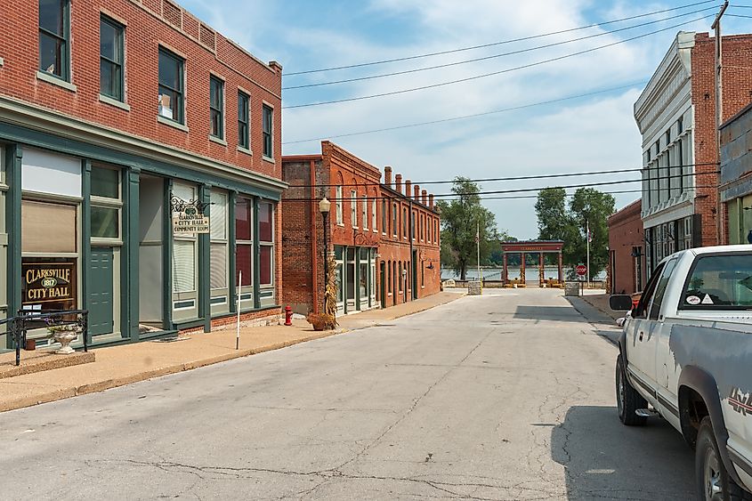 Main Street in Clarksville, USA, a small town lined with typical red brick buildings leading to the Mississippi River.