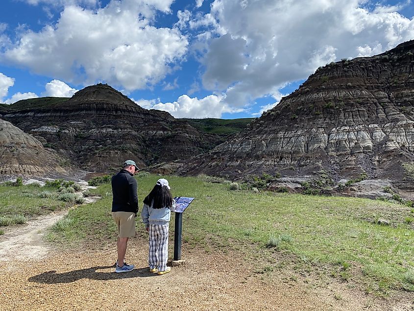 A man and a woman read an interpretive sign along a scenic badlands trail