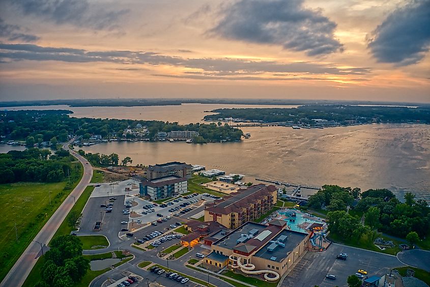 Aerial view of Lake Okoboji at sunset in northern Iowa, with calm water reflecting the colorful sky.