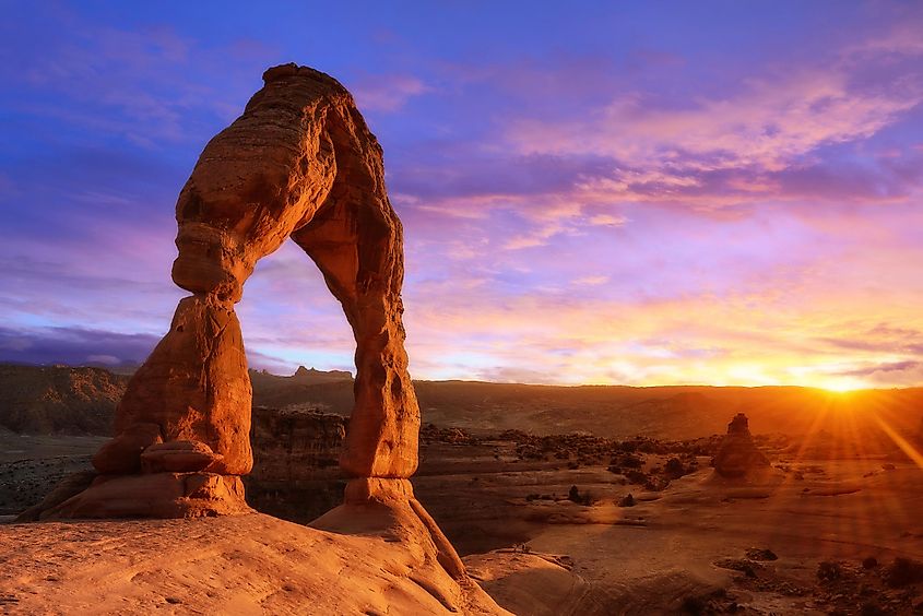 Warm-toned and softly lit sunset at Delicate Arch in Arches National Park, Moab, Utah, USA.