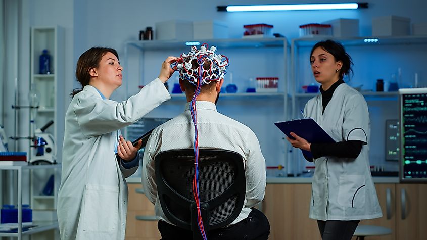 Man wearing a brain scanning device with doctors.