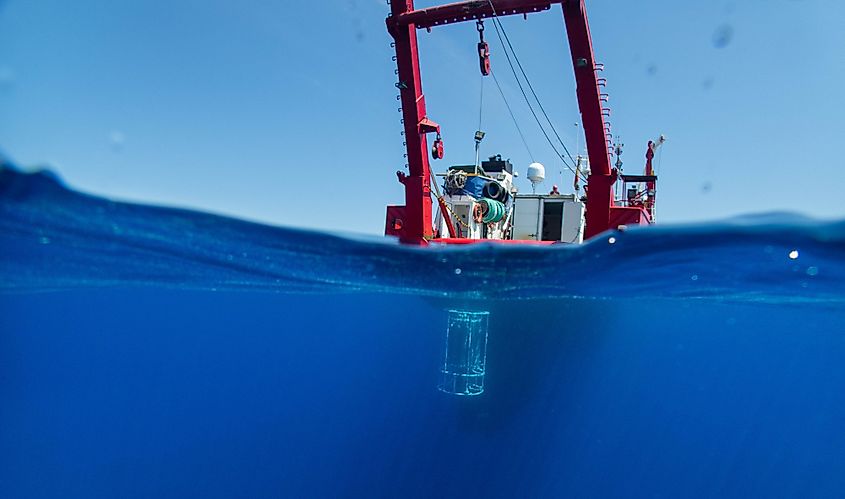 A research vessel floats submerges equipment prepared for scientific study