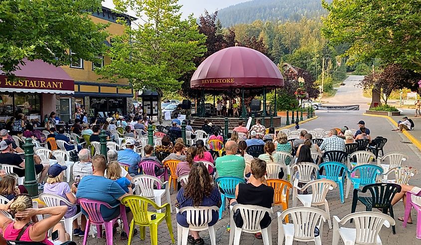 A crowded downtown with lots of people sitting and listening to a concert in downtown, Revelstoke, British Columbia, Canada.