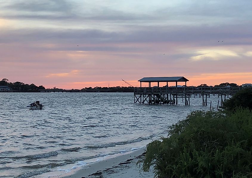 A sailboat is moored near a wooden pier in Cedar Key, Florida.