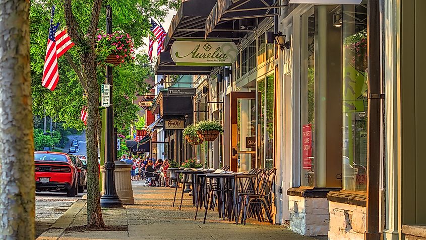 Summer late afternoon scene of sidewalk and shops on Main Street in the business district of historic downtown Chagrin Falls, Ohio, USA