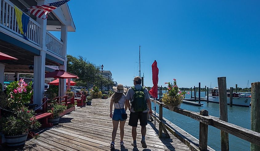 People walking on the boardwalk by the water. Inner Banks. Beaufort, North Carolina, USA.