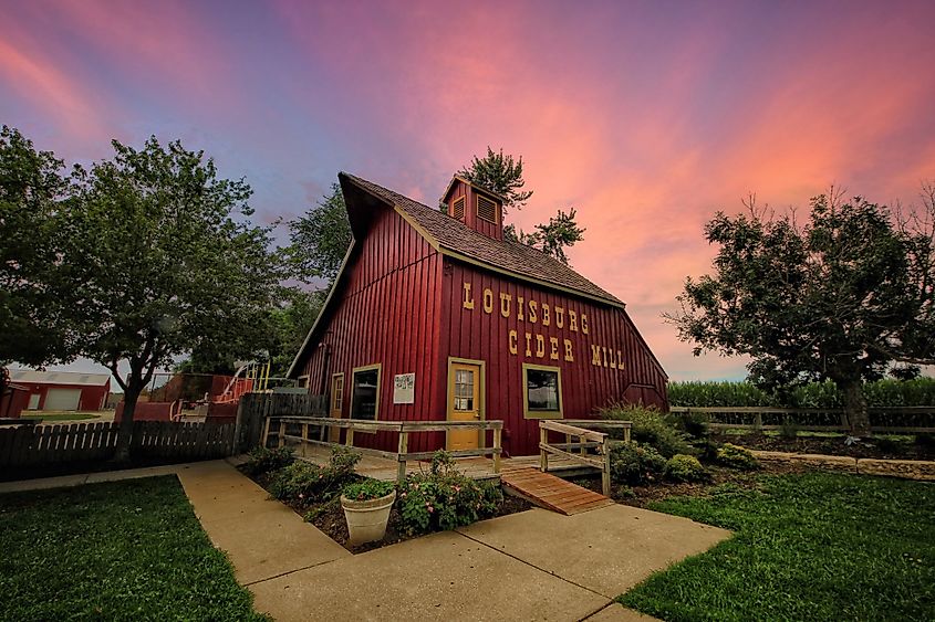 Louisburg Cider Mill at sunset in the summertime, with warm light casting a golden glow over the historic mill