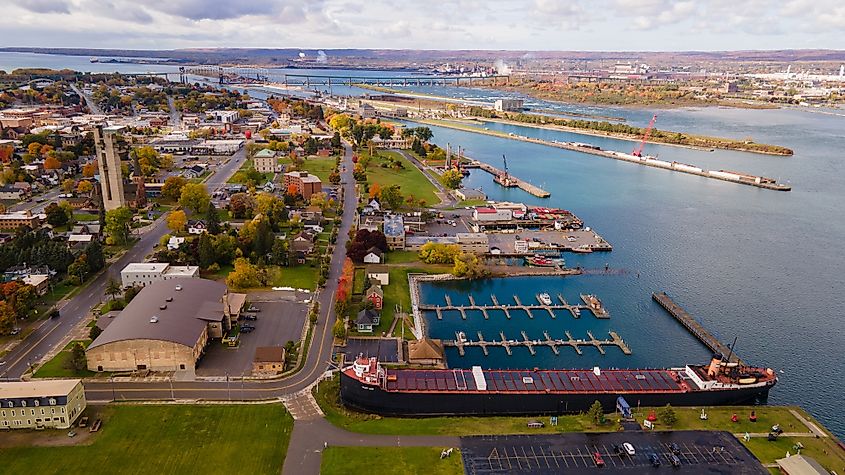 This aerial photo showcases the Soo Locks in Sault Ste Marie, Michigan, on a partly cloudy autumn day, providing a unique perspective of the lock systems and surrounding fall foliage.