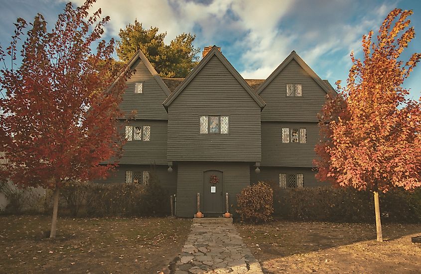 The Salem Witch House in Fall with bright red trees out front