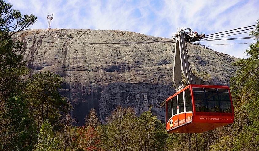 Red Skyride cable car in front of Stone Mountain Summit with famous rock relief, the largest bas-relief in the world.