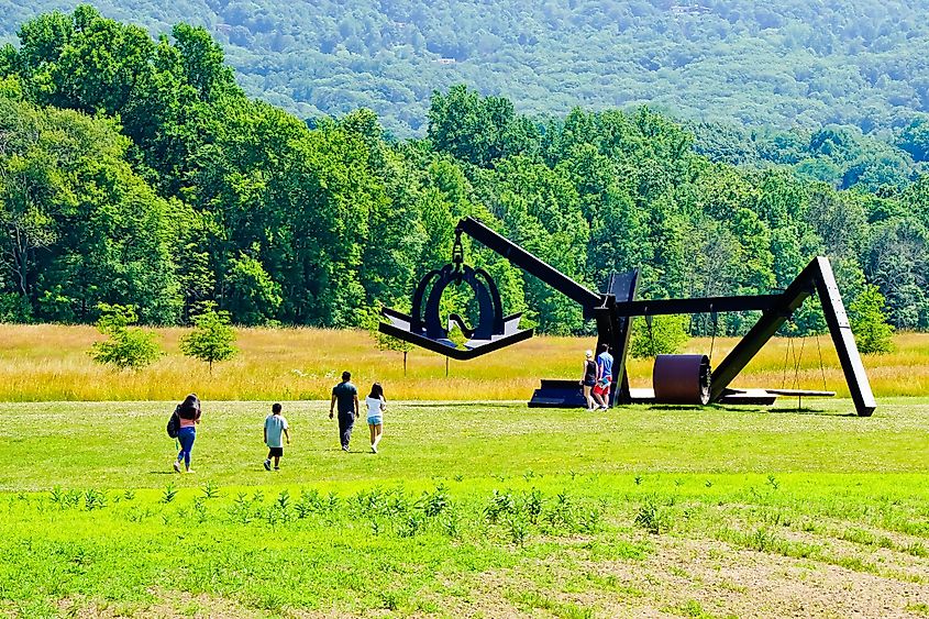 tourists visiting new addition of sculpture of “she” by Mark DI Suvero in storm king art center, via Yingna Cai / Shutterstock.com