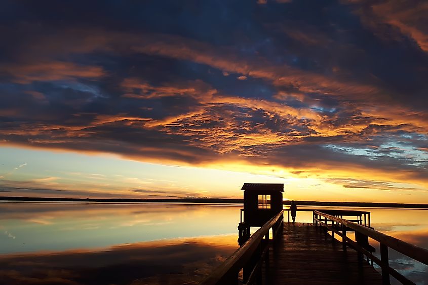 A man standing on a pier at sunset in Brighton, Michigan