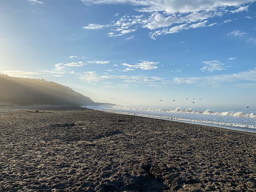 The morning sun crests the Marin Hills to reveal the rugged beauty of Stinson Beach, California.