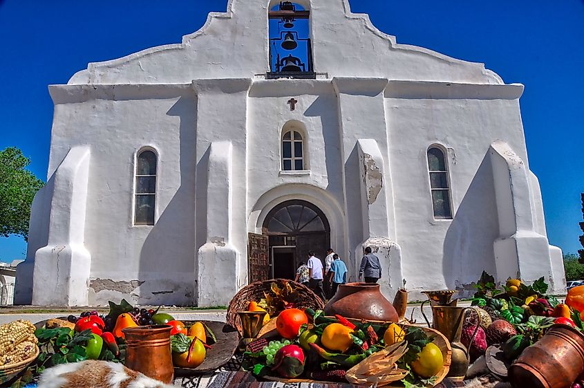 Celebrating Thanksgiving Tables full of food and valuables like jewelry are lined up in front of the church.