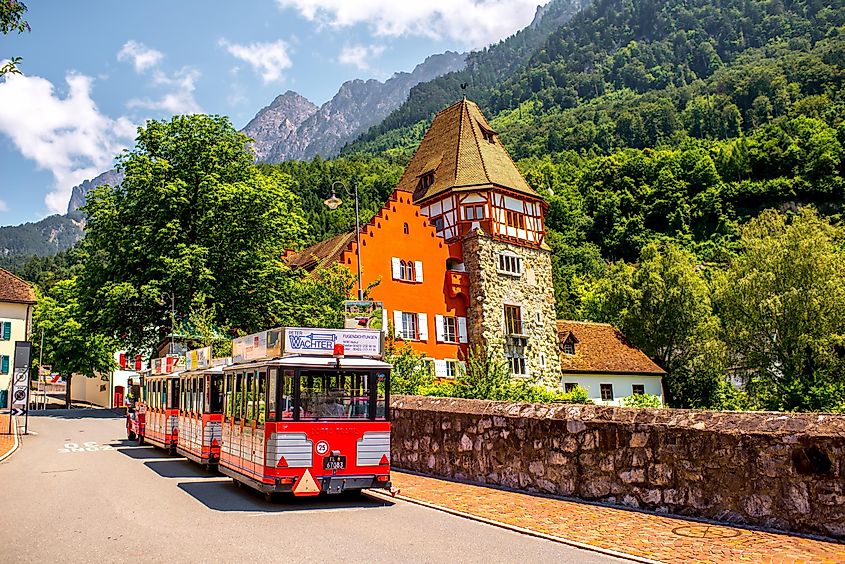 People on the tourist train visit famous red house with wineyard in Vaduz city