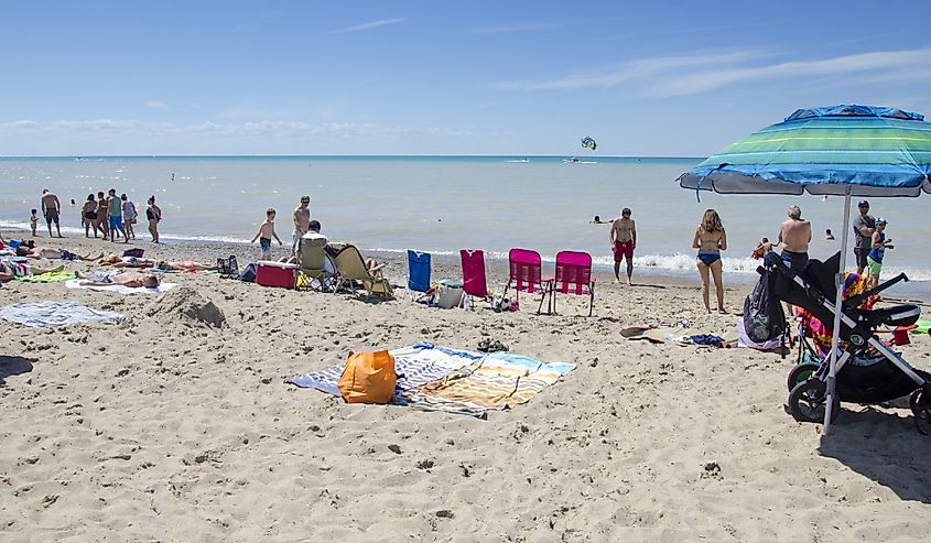 Unidentified people in the beach of the lake Grand Bend in leisure acivities in summertime in a deep blue sky