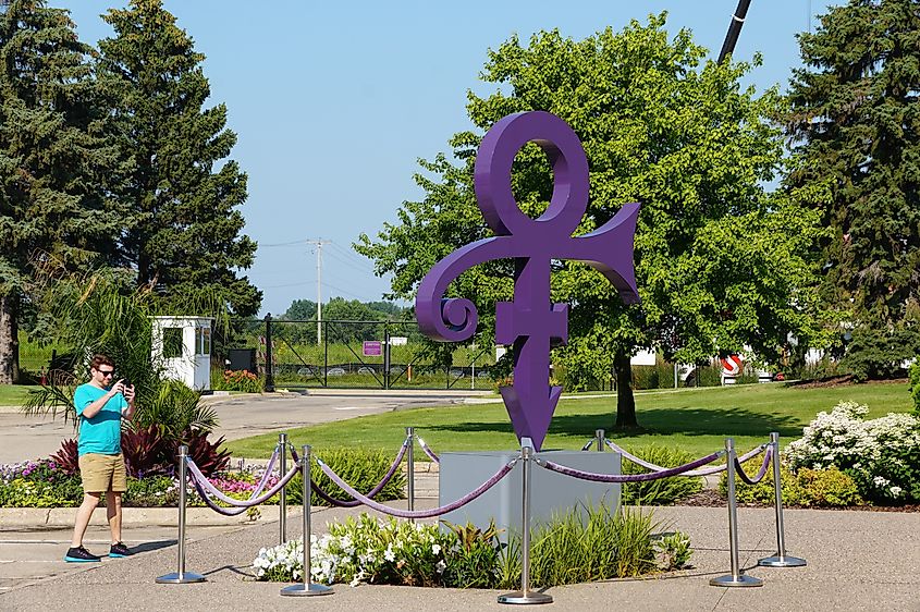 A visitor taking the picture of the purple symbol that represents the singer Prince in front of the museum at Paisley Park. Editorial credit: Khairil Azhar Junos / Shutterstock.com