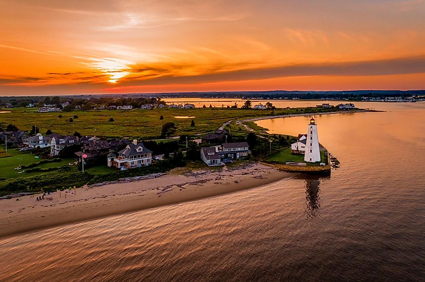 Summer sunset in Old Saybrook along the Connecticut River with Lynde Lighthouse in the foreground and a summer sunset By Gregory on Adobe Stock