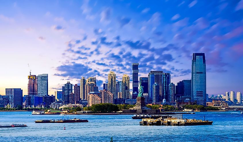 The skyline of Jersey City, New Jersey from New York Harbor with the Statue of Liberty in the foreground