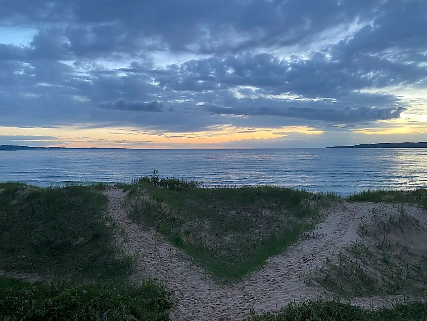 A post-sunset glow peaks through evening clouds overtop of Little Traverse Bay