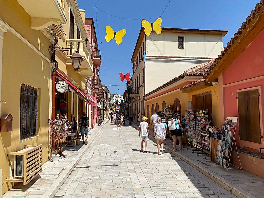 Yellow butterfly sculptures hang over the pedestrian street of a colorful mock Old Town.