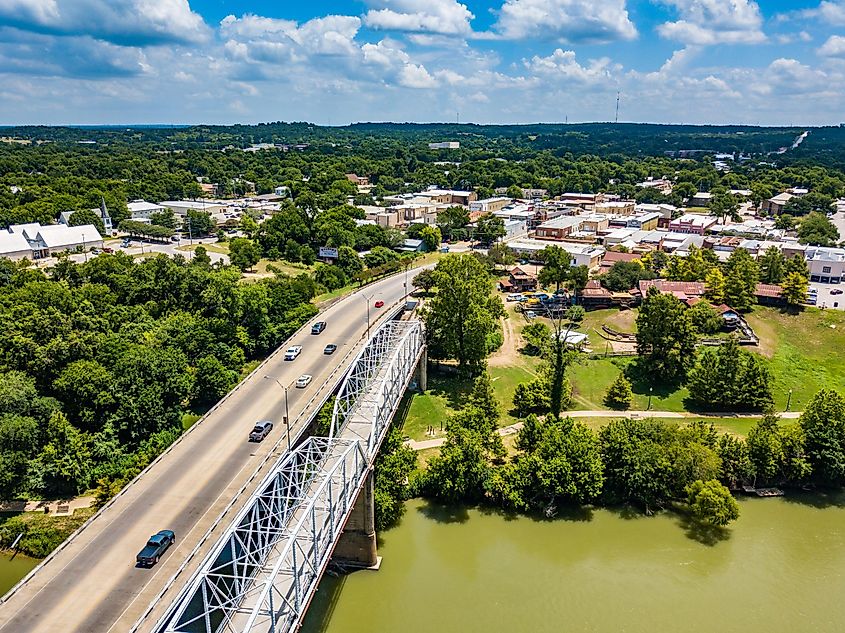 Summer aerial view of downtown Bastrop, Texas, showcasing the historic bridge over the Colorado River.