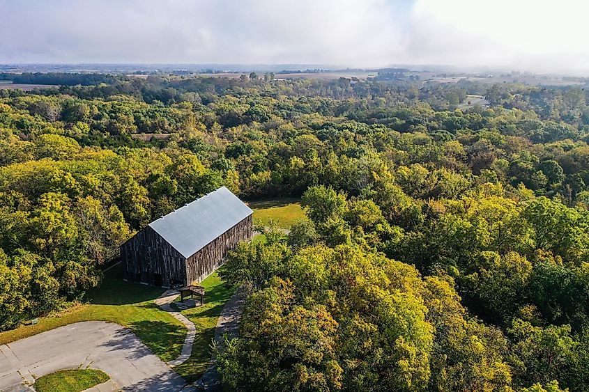 Aerial drone photo of an old, historic, tobacco barn in the public Weston Bend State Park in Missouri north of Kansas City. Trees are just getting their fall colors.