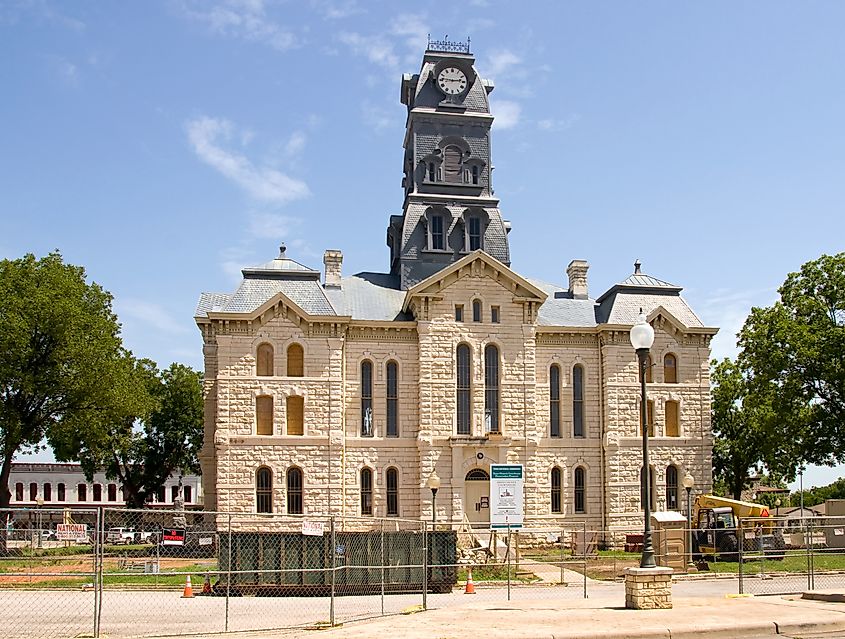 Hood County Courthouse in Granbury, Texas, undergoing renovation, with scaffolding surrounding the historic building during the restoration process.