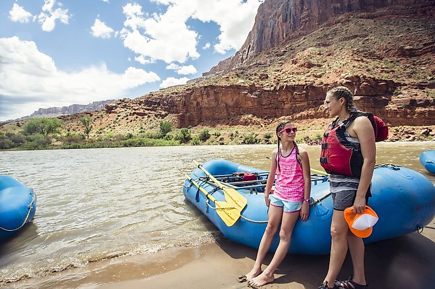 Smiling child and adult women ready to board a large inflatable raft as they travel down the scenic Colorado River near Moab, Utah and Arches National Park.