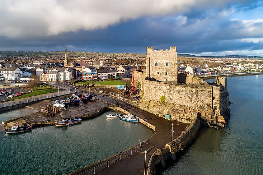 Medieval Norman Castle, harbor with boat ramp and wave breaker in Carrickfergus near Belfast, Northern Ireland, UK. 