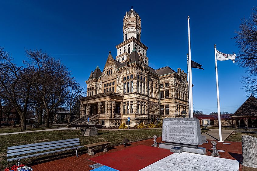 Jerseyville, Illinois; flags fly on poles at the veterans memorial in front of the 1800s civil war era stone courthouse 