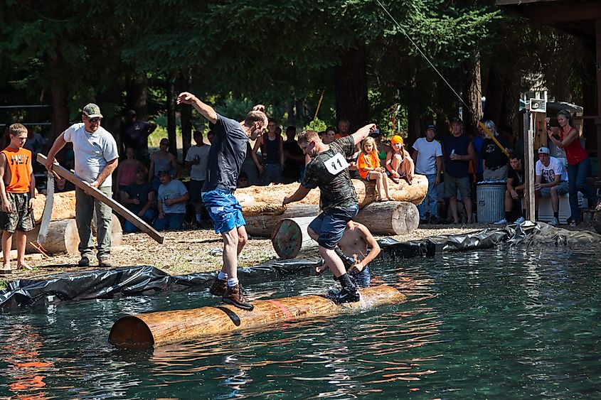 Two men compete in the log rolling skill event at the Prospect Hillbilly Jamboree and Timber Carnival in Prospect, Oregon. Image by Tami Freed via Shutterstock.com